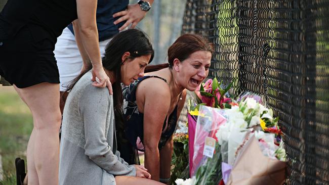 Mother Leila Abdallah, wearing a grey cardigan, grieves at the site on Sunday where three of her children where killed in a car crash. Picture: Adam Yip