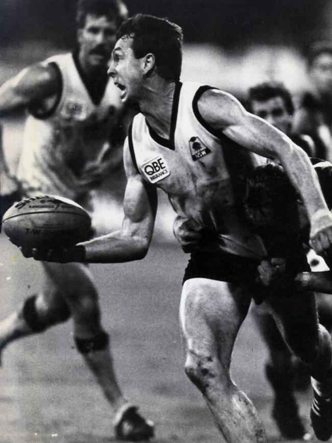 Terry Daniher fires off a handball for NSW in 1990.