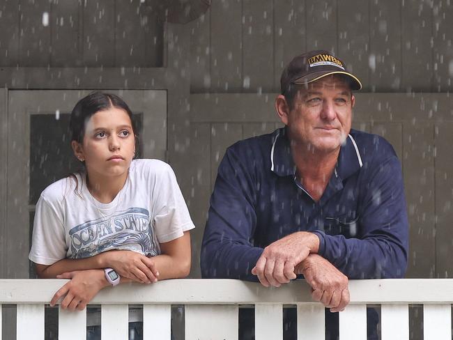 Neighbours Ross Bennett and Annabella Giorgas 11 watch on  in Hermit Park as Townsville residents endure another day of heavy rain and threats of catastrophic flooding. Pics Adam Head