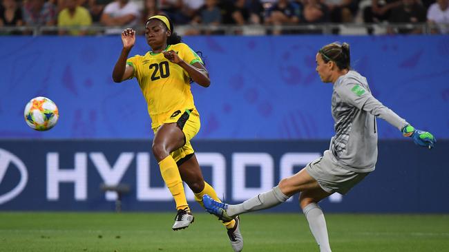 Busy night … Australian goalkeeper Lydia Williams (right) clears ahead of the challenge of Jamaican midfielder Cheyna Matthews. Picture: AFP