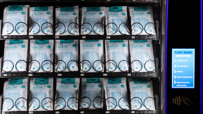 Disposable surgical face masks are displayed for sale in a vending machine at Terminal 1 of Manchester Airport.