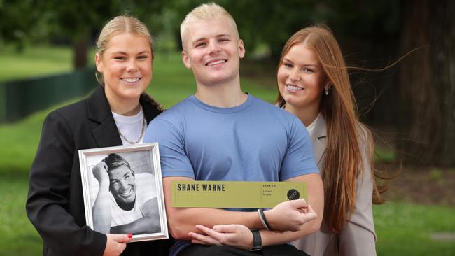 Brooke, Jackson and Summer Warne hold their dad’s legend plaque at the MCG. Picture: David Caird