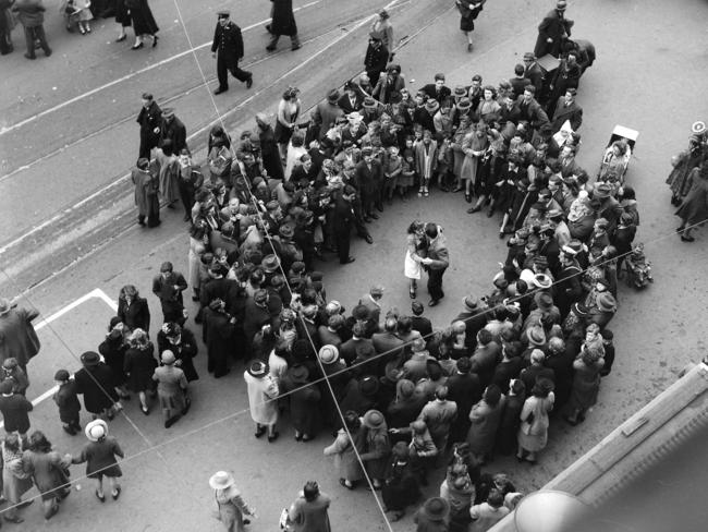 Onlookers watch a couple dance in Macquarie Street, Hobart, during VP Day celebrations.