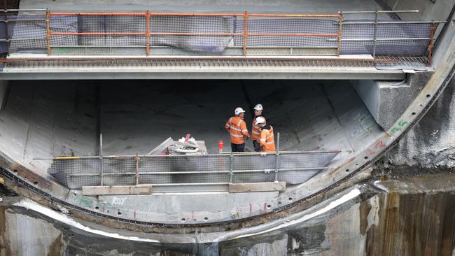 Concrete safety barriers are being attached to walls and drainage and mechanical systems assembled by teams of workers. Picture: David Caird