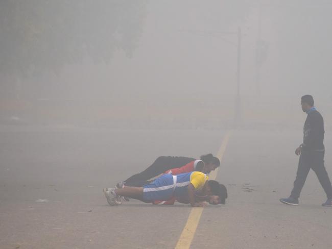 Indian fitness enthusiasts work out amid heavy smog near India Gate in New Delhi last week. Picture: Dominique Faget/AFP