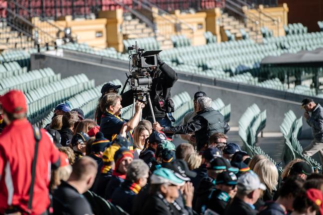 FIlm crew are seen setting up in front of Crows and Port Adelaide fans for the film 