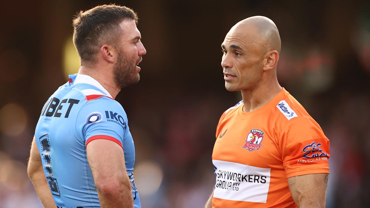 James Tedesco of the Roosters is attended to by a trainer after a tackle made by Jordan Pereira of the Dragons.