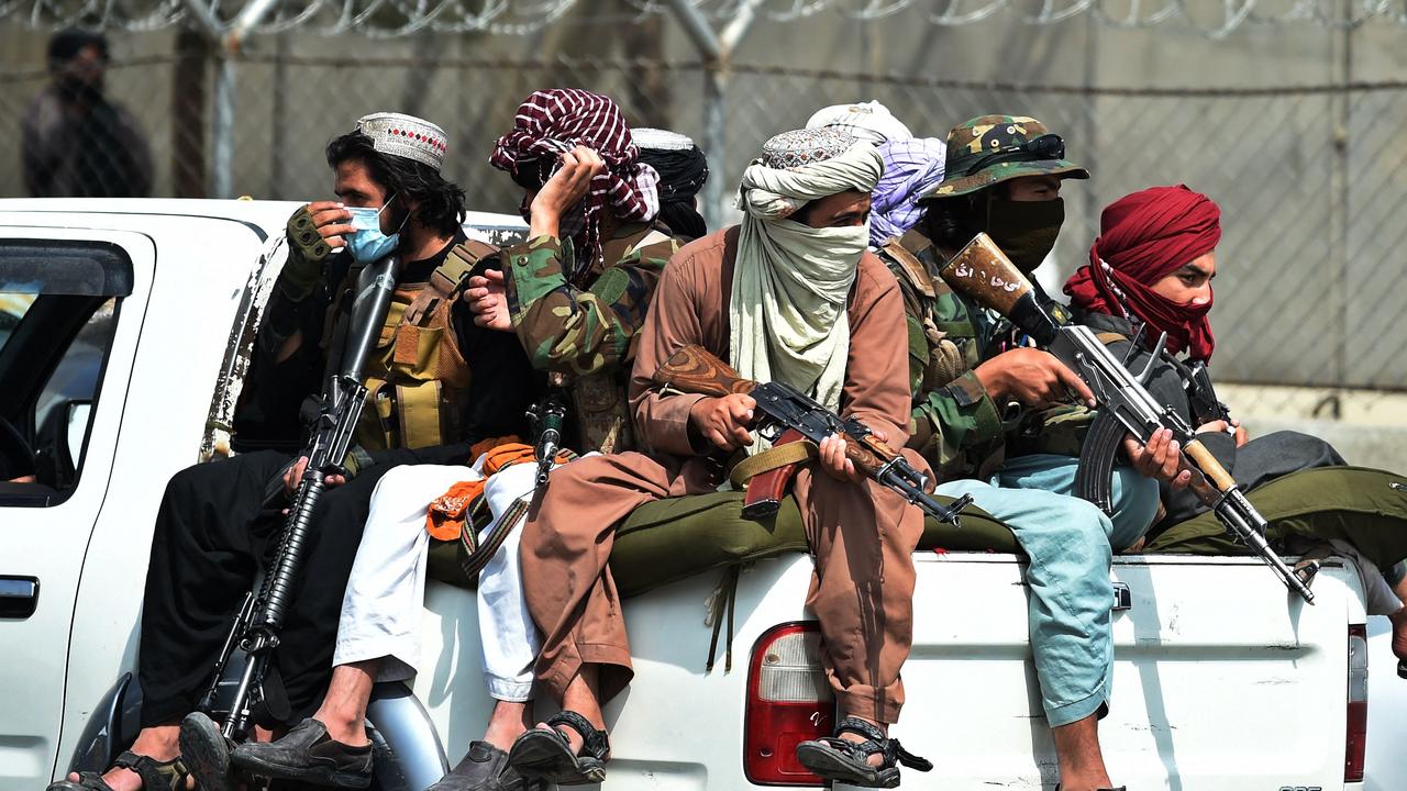 Taliban fighters guard outside the airport in Kabul.