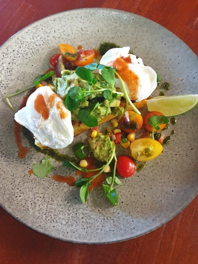 Cajun style grilled corn bread with poached eggs, smashed avocado, tomato talsa and bloody mary drizzle