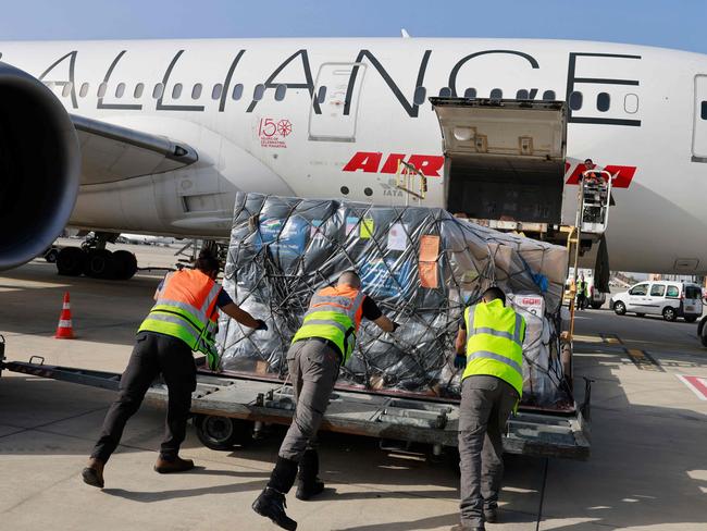 Workers load medical aid to be flown in an Air India aeroplane to India, at Israel's Ben Gurion Airport near Tel Aviv, on May 4, 2021. - India's total COVID-19 caseload neared 20 million as oxygen shortages in hospitals exacerbated a devastating second wave, and much-needed foreign assistance continued to pour in. (Photo by Menahem KAHANA / POOL / AFP)