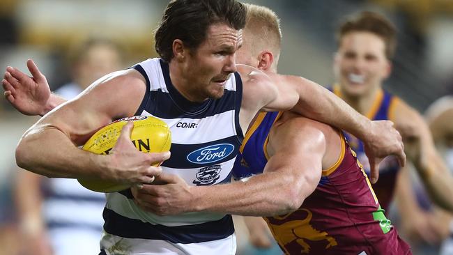 Patrick Dangerfield busts through another tackle.