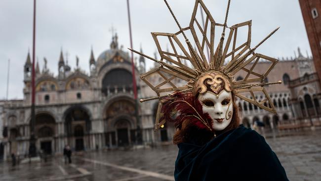 A Venetian artisan wearing a carnival mask and costume takes part in a demonstration of The Confederation of Venice Artisans (Confartigianato Venezia) at St Mark's square in Venice after the carnival was cancelled. Picture: AFP