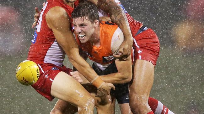 Aidan Corr is tackled by Sam Reid and Lance Franklin.