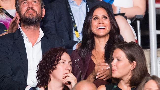 Markle sat with her friend Mark Anderson. Picture: Nathan Denette / The Canadian Press / AP.