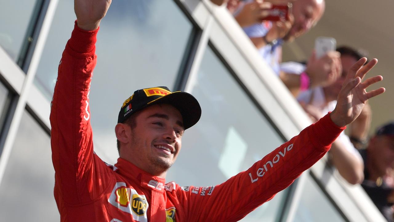 Charles Leclerc waves to fans as he arrives on the podium in Monza.