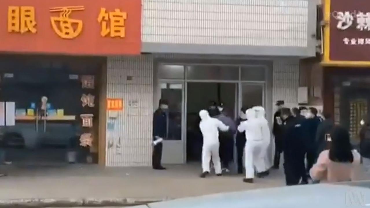 Footage from Four Corners showing people being dragged out of buildings and put into quarantine.