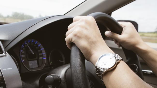 male hands on steering wheel on the right with country side view