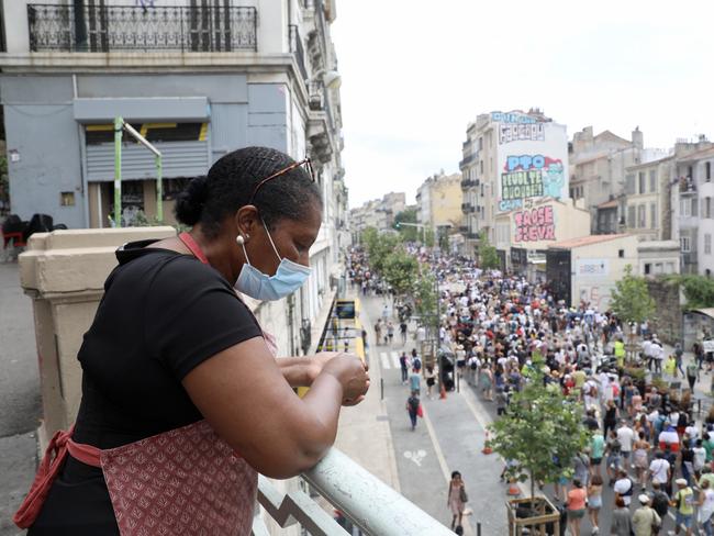 A woman watches as anti-vaccine protesters march in Marseilles. Picture: Getty Images