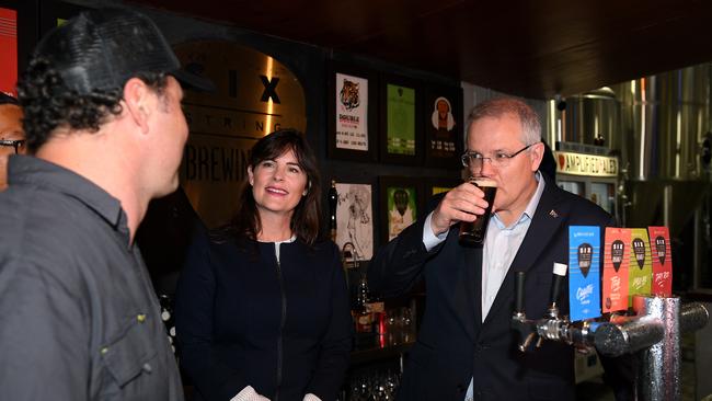 Australian Prime Minister Scott Morrison pours a beer during a visit with Federal MP for Robertson Lucy Wicks (centre) and co-owner Ryan Harris (left) to the Six Strings Brewery in Erina on the NSW Central Coast, Wednesday, October 10, 2018. (AAP Image/Dan Himbrechts) NO ARCHIVING