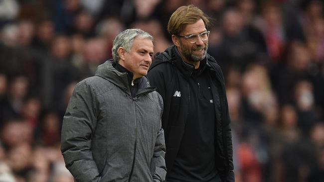 Manchester United's Portuguese manager Jose Mourinho (L) talks with Liverpool's German manager Jurgen Klopp (R)