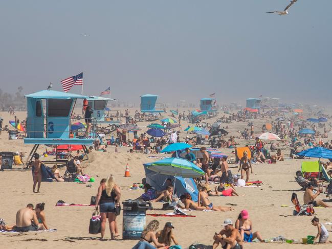 ‘People are getting restless to leave their homes’ ... a packed beach in California. Picture: AFP