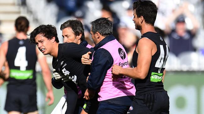 Jack Silvagni in the hands of trainers after injuring his shoulder.