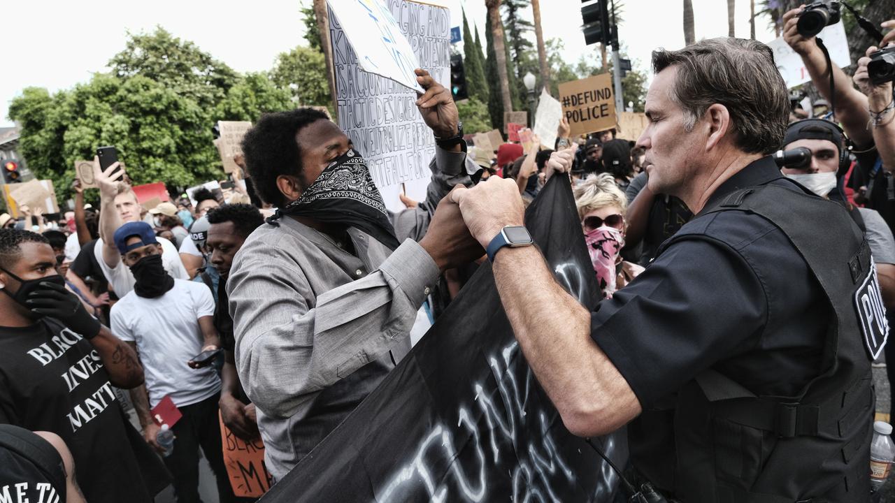 Los Angeles Commander Cory Palka (R) reaches out and offers a handshake to a Black Lives Matter protester outside Los Angeles Mayor Garcetti's house in Los Angeles. Picture: AP/Richard Vogel