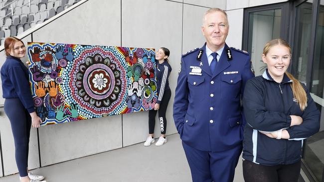 Students Shania Flint, Tenisha-Ann Brooks and Toyah Fenton present a mural to NSW Police Commissioner Mick Fuller.  Picture: Toby Zerna