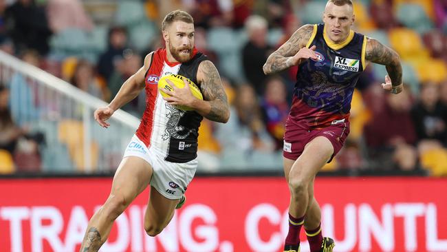 Dean Kent of the Saints leaves Mitch Robinson of the Lions in his wake. Pic: Michael Klein