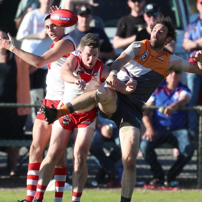 Giants’ player Jake Garvey does battle with two Ararat opponents.