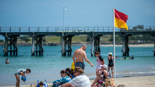 Jetty beach flags and lifeguards,holiday makers at the beach. 16 JAN 2020