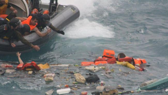 Rescuers from an Australian navy vessel drag asylum-seekers from the water after their boat was dashed on the cliffs of Christmas Island. Picture: Nine Network