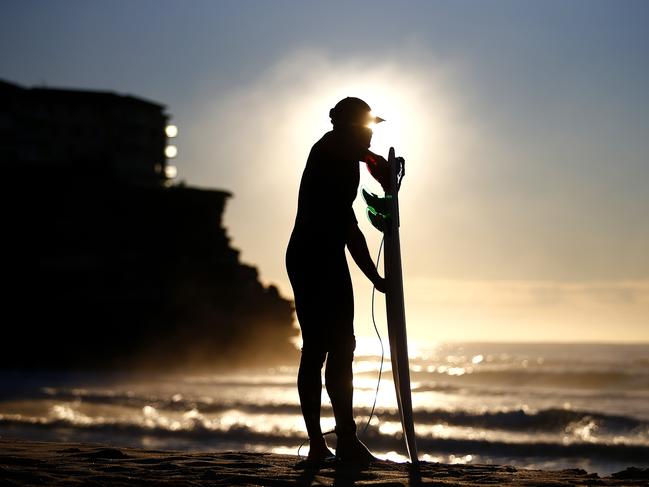 7:26am – A surfer prepares to enter the waters of Queenscliff beach, Manly.