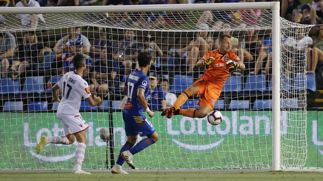 Nikola Mileusnic scores in the first half for Adelaide United after the ball ricochets from the goalpost onto Jets keeper Glen Moss. Picture: AAP