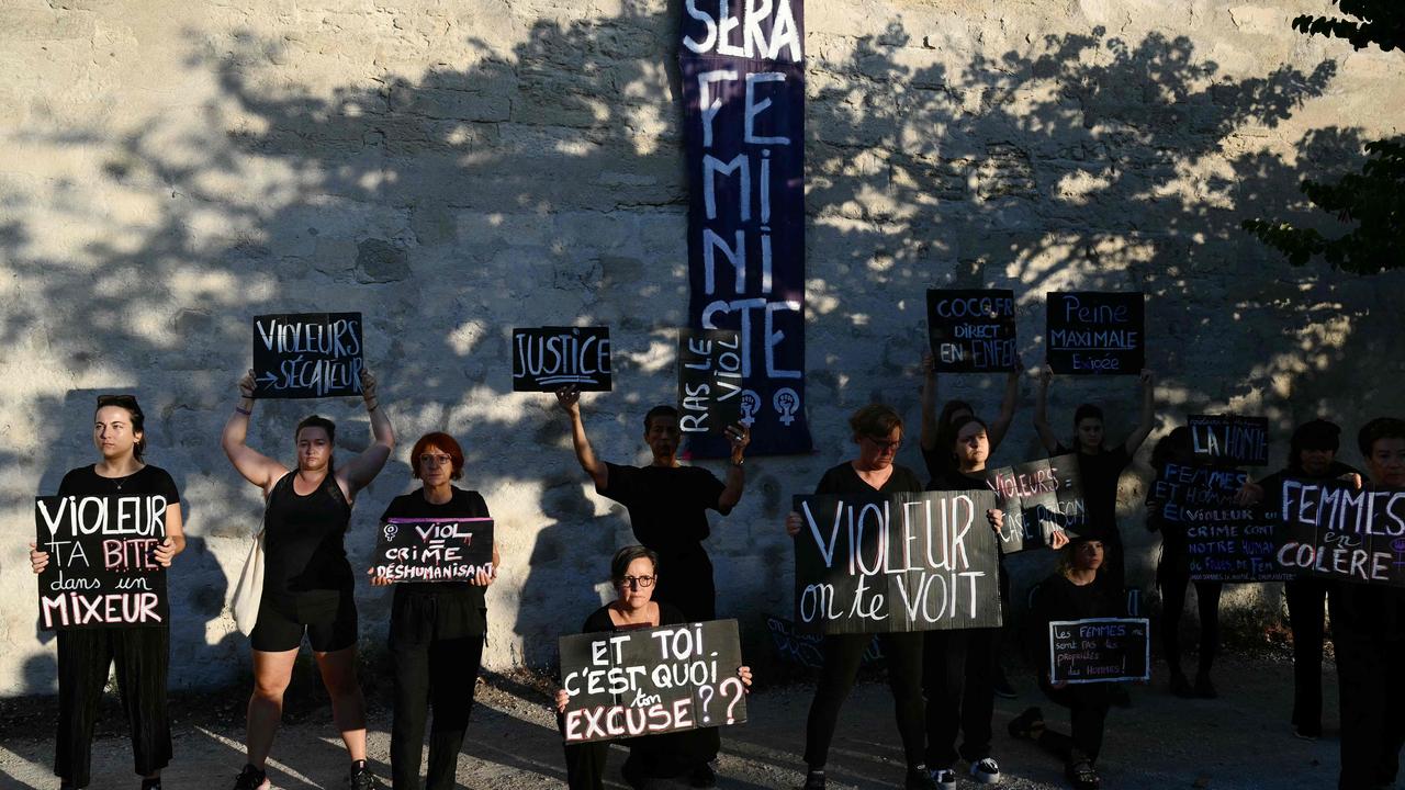 Demonstrators hold placards during a protest outside the courthouse. Picture: Christophe Simon/AFP