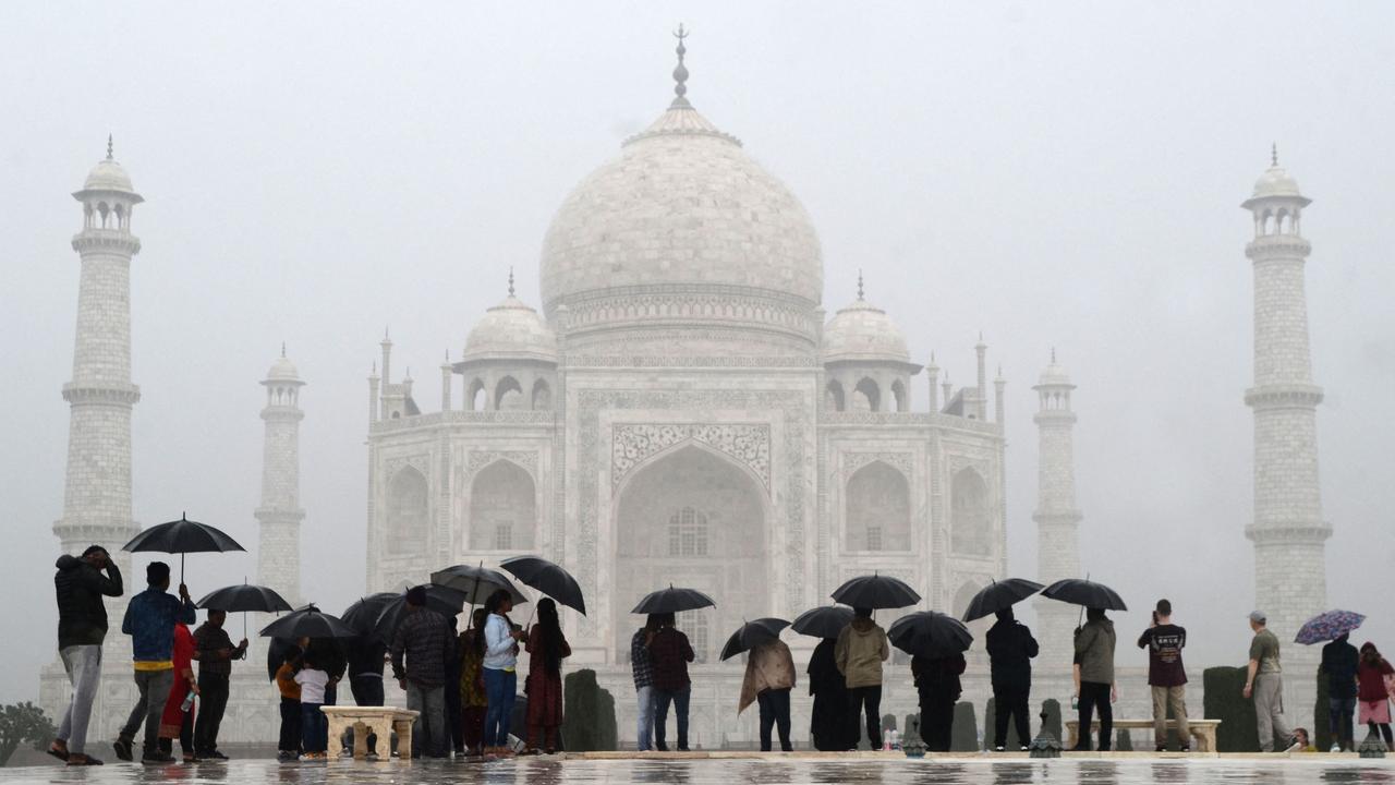 Tourists make the most of a rainy and deserted Taj Mahal. Picture: Pawan Sharma/AFP