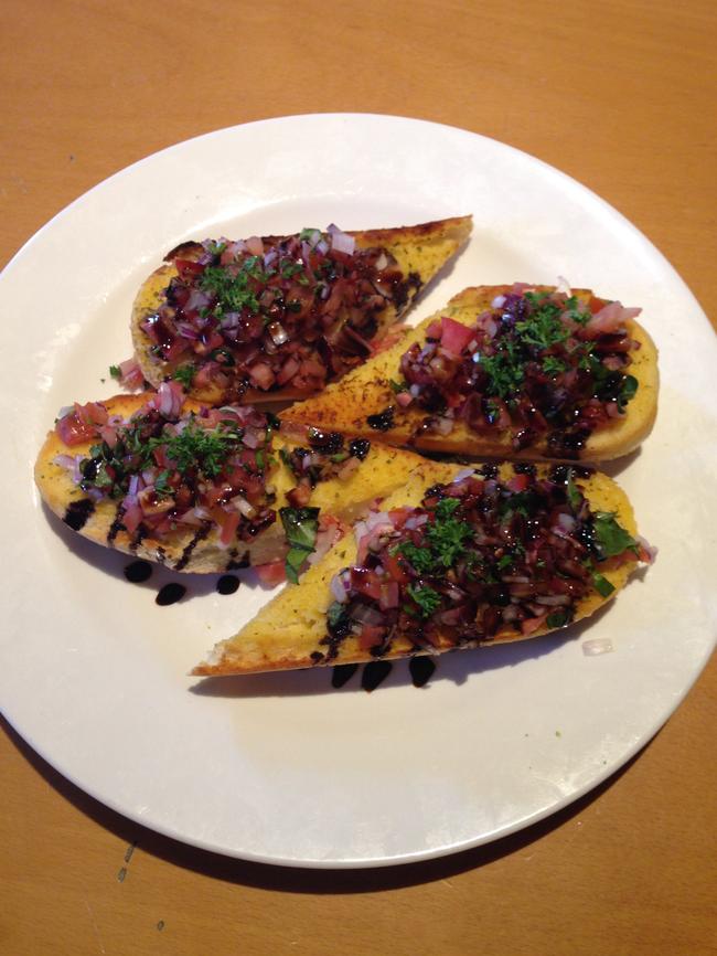 The bruschetta is served with fresh tomato, onion and herbs.