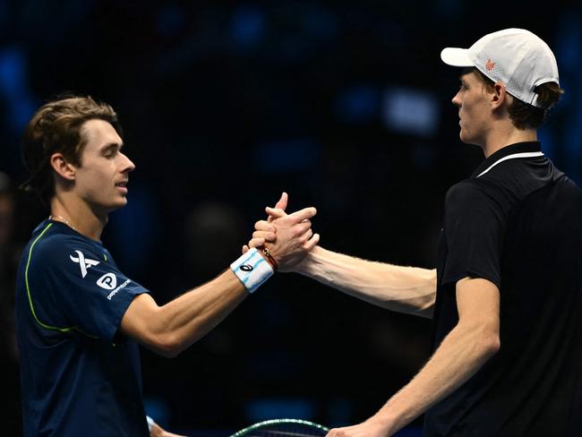 Italy's Jannik Sinner (R) shakes hands with Australia's Alex de Minaur after winning his match at the ATP Finals tennis tournament in Turin on November 10, 2024. (Photo by Marco BERTORELLO / AFP)