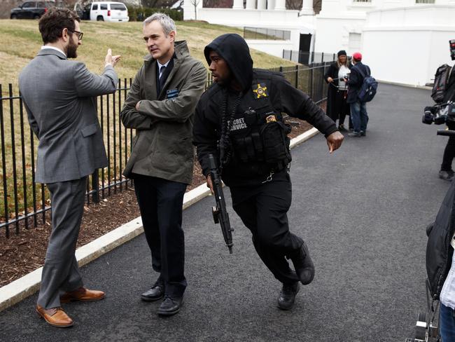 A Secret Service officer rushes past reporters after a vehicle rammed into the security barrier near the White House. Picture: AP Photo/Evan Vucci