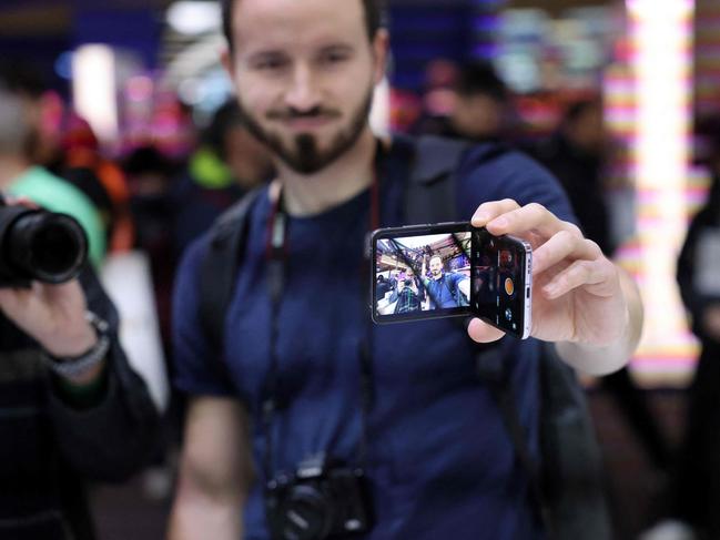 A visitor holds a new mobile phone on Oppo stand at the Mobile World Congress. Picture: Thomas COEX / AFP