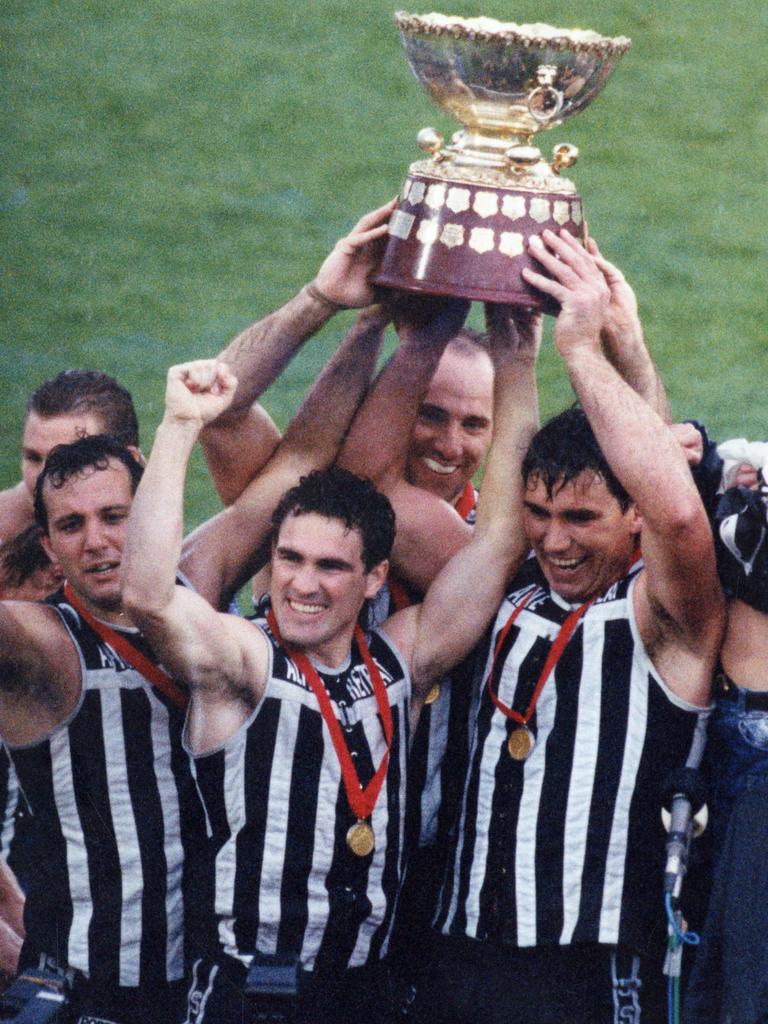 George Fiacchi (left) and Tim Ginever (centre) hold the 1992 premiership cup aloft with star teammate Greg Phillips. Picture: BARRY O’BRIEN.