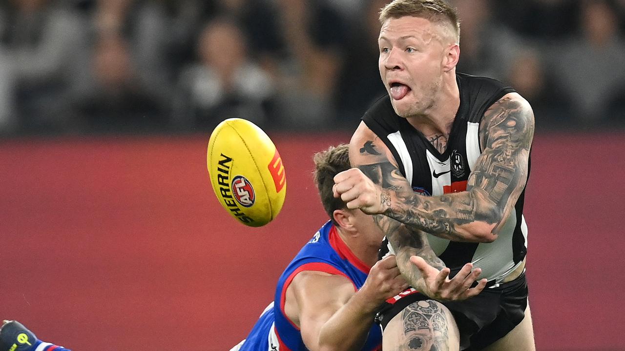 Jordan De Goey handballs while being tackled by Jackson Macrae. Picture: Quinn Rooney/Getty Images