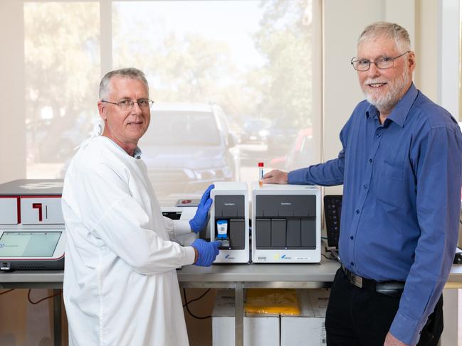 Alice Springs Hospital Pathology Department microbiology supervising scientist James McLeod and laboratory manager David Hallett with the unit used to process coronavirus tests. Photo: EMMA MURRAY