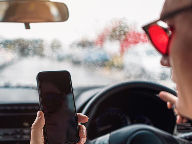 Distracted Driver Talking On Mobile Phone On Rainy Urban Street