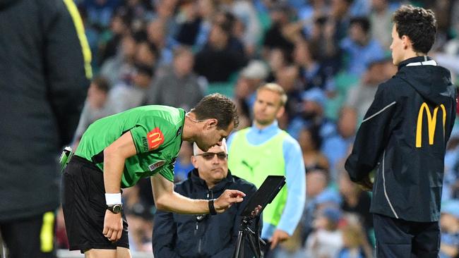 Referee Chris Beach examines the VAR. Picture: AAP