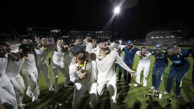 Nathan Lyon and Steve Smith celebrate with team mates while singing the team song on the pitch after Australia claimed victory to retain the Ashes.