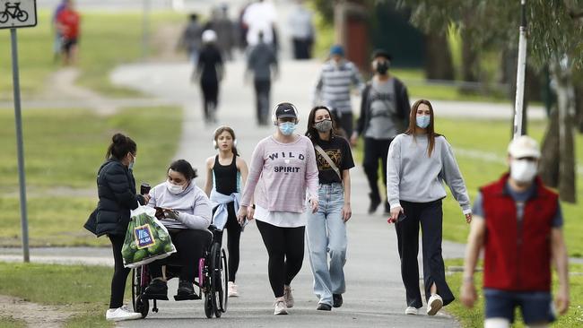 Walkers don masks for exercise at Princes Park. Picture: Daniel Pockett