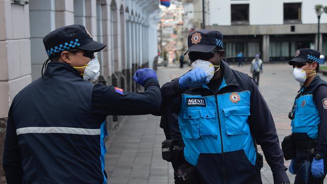 Policemen wearing face masks and gloves greet without using hands at Plaza Grande Square in Quito, on March 19, 2020. Picture: RODRIGO BUENDIA.