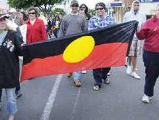 Pride on display: Marchers proudly carry the Aboriginal flag during yesterday’s NAIDOC Week mark in River Street, Ballina. . Picture: Doug Eaton