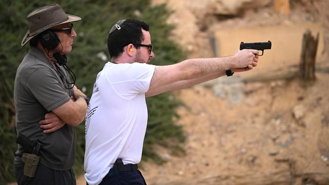 A member of the public receives weapons training from a tutor at a shooting range in Israel. Since the Hamas attack, the training centre has seen an increase in requests for both civilians and military services. Picture: Leon Neal/Getty Images